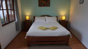 a bedroom with a bed with two pillows and two lamps at Ventana Sur Hostal in Santiago