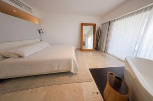a bedroom with a bed and a sink and a mirror at Beautiful apartment by the beach! in Cancún