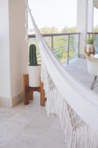a hammock in a living room with a balcony at Beautiful apartment by the beach! in Cancún