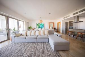 uma sala de estar com um sofá branco e uma mesa em Beautiful apartment by the beach! em Cancún