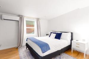 a white bedroom with a large bed with blue pillows at Cozy & Modern 1st-fl Guest house in San Diego