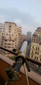 a telescope on a ledge in a city with buildings at Spacious Panthouse Center of Cairo exotic location in Cairo