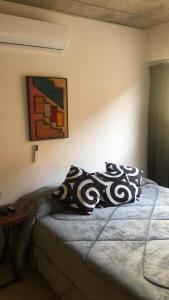 una camera da letto con un letto con un cuscino sopra di Belgrano suite a Salta