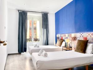 マドリードにあるCharming Puerta del Sol Centerのベッド2台とソファが備わるホテルルームです。