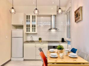 a kitchen with a wooden table with chairs and appliances at Charming Puerta del Sol Center in Madrid