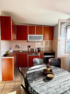 a kitchen with a table with chairs and a kitchen with red cabinets at City Center Square DeLuxe Nest in Podgorica