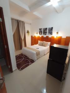 a white bedroom with a bed and a dresser at Central Palace Hotel in Fortaleza