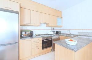 a kitchen with wooden cabinets and a bowl of fruit on the counter at Villa Julia in Riumar