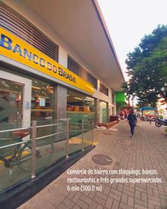 Casa Temporada no Rio de Janeiro في ريو دي جانيرو: امرأة تمشي على الرصيف أمام متجر