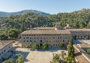 an aerial view of a building with mountains in the background at Santuari de Lluc in Lluc