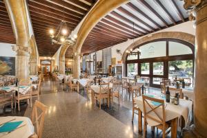 un restaurant avec des tables et des chaises dans un bâtiment dans l'établissement Santuari de Lluc, à Lluc