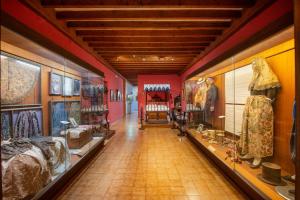 a hallway of a museum with lots of clothes on display at Santuari de Lluc in Lluc