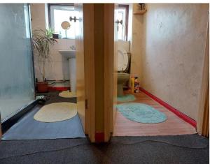 a bathroom with a toilet and four rugs on the floor at Basildon House in Basildon