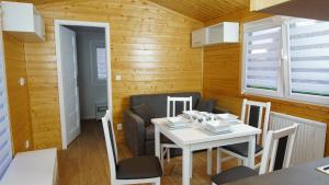 a small dining room with a white table and chairs at Bungalow Camping Bieska Osada in Solina