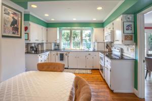 a kitchen with white cabinets and green walls at Highland Park House in Walla Walla