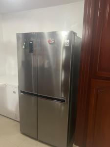 a stainless steel refrigerator sitting in a kitchen at Atardecer dorado in Juan López