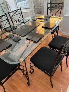 a glass dining table with black chairs around it at Alder House in Birmingham