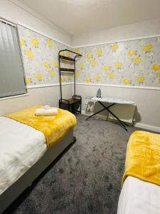 a bedroom with two beds and a table in it at Alder House in Birmingham
