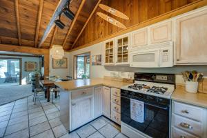 a kitchen with white cabinets and a stove top oven at Delton Oasis Retreat with Lake Views and Deck! in Delton