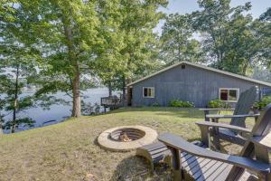 a backyard with two chairs and a fire pit at Delton Oasis Retreat with Lake Views and Deck! in Delton
