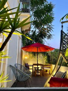 里斯本的住宿－里斯本客人公寓酒店，一个带桌子和红色遮阳伞的庭院