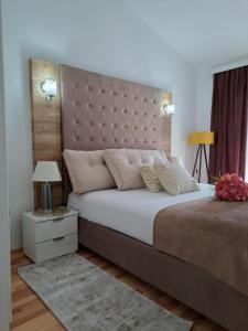a bedroom with a large bed with a large headboard at Apartments Pepdjonovic in Ulcinj