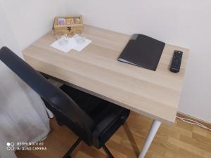 a wooden desk with a laptop and a phone on it at MCR Barreiro - Lisboa in Lavradio