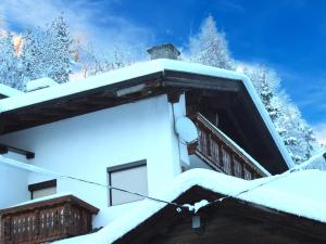 a house covered in snow with trees in the background at Ferienhaus Dias in Kappl