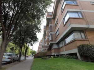 ein großes Backsteingebäude mit grünem Rasen davor in der Unterkunft Habitación 2 en sector exclusivo Usaquen in Bogotá