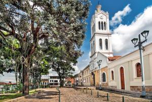 eine Kirche mit einem Uhrturm auf einer Straße in der Unterkunft Habitación 2 en sector exclusivo Usaquen in Bogotá