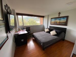 ein Schlafzimmer mit Bett, Schreibtisch und Fenster in der Unterkunft Habitación 2 en sector exclusivo Usaquen in Bogotá