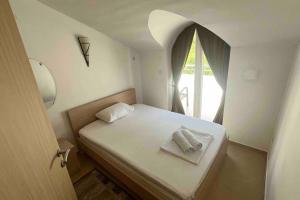 małą sypialnię z łóżkiem z oknem w obiekcie Cosy 2-bedroom apt 100m from sea w mieście Herceg Novi