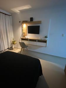 sala de estar con TV y cama en Edificio del Sur en Santiago del Estero