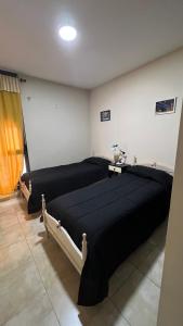 a bedroom with two beds and a lamp on a table at Departamento Centrico in Villa María
