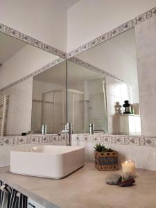 uma casa de banho com um lavatório branco e um espelho. em Donny Dude Panorama em Gênova
