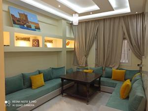 un salon avec un canapé et une table dans l'établissement شقة بإقامة الجوهرة الصويرة الصويرة, à Essaouira