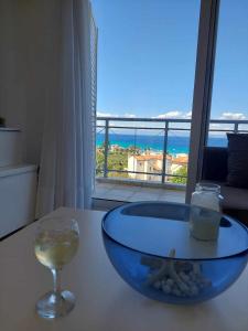 a wine glass and a bowl on a table with a view at Christina's panoramic view appartment in Polychrono