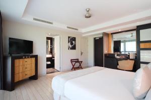 a bedroom with a bed and a flat screen tv at Te Moana Tahiti Resort in Punaauia