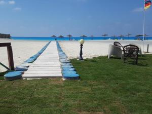 a dock on the beach with a table and a bench at Chalet in Mena 4 in Dawwār ‘Abd al ‘Aţī Abū ‘Ajūz +1 photo