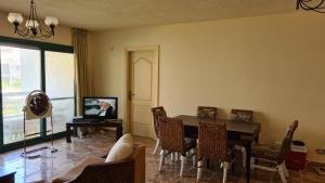 a living room with a table and chairs and a tv at Chalet in Mena 4 in Dawwār ‘Abd al ‘Aţī Abū ‘Ajūz