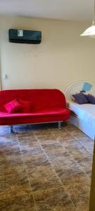 a red couch sitting next to a bed at Chalet in Mena 4 in Dawwār ‘Abd al ‘Aţī Abū ‘Ajūz