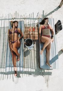 two women in bathing suits sitting on beds at Las Nubes de Holbox in Holbox Island
