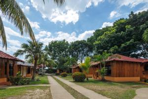 a row of cottages in a resort with palm trees at H4 LAS CABAÑAS in Corozal