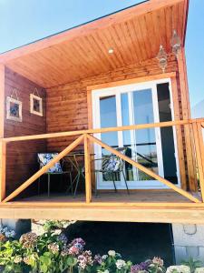 a wooden cabin with a deck with a window at Varzea Nature in Torres Vedras