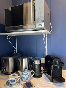 a kitchen counter with a microwave and some pots and pans at The Boat House Studio in Tairua