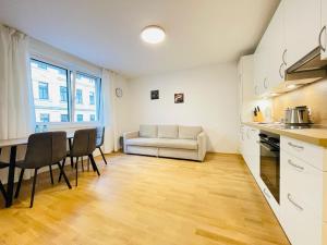 eine Küche und ein Wohnzimmer mit einem Sofa und einem Tisch in der Unterkunft Vienna Style Apartment in Wien