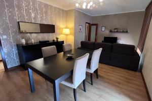 a living room with a black table and white chairs at S. Mamede House - Penafiel in Recezinhos