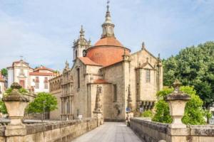 an old building with a red roof on a bridge at S. Mamede House - Penafiel in Recezinhos