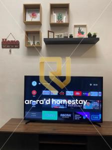 TV de pantalla plana en la parte superior de una mesa en Ar-Ra’d Homestay Semporna en Semporna