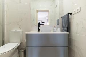 a white bathroom with a sink and a toilet at Best House Center - with Garage in Porto